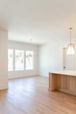 Kitchen with a chandelier, light wood-type flooring, and pendant lighting