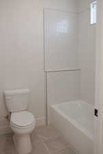 Full bath with baseboards, toilet, and tile patterned flooring