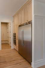 Kitchen with stainless steel appliances, light wood-style flooring, and light brown cabinets
