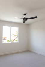 Unfurnished room featuring ceiling fan, baseboards, and light colored carpet
