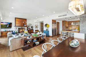 Living area with wood finished floors, ornamental molding, a fireplace, and recessed lighting
