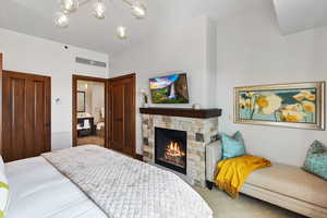 Bedroom featuring a fireplace and a chandelier