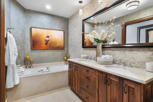 Bathroom with tile patterned flooring, a garden tub, and double vanity