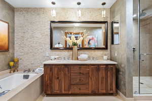 Bathroom featuring a shower stall, a garden tub, tile patterned flooring, and double vanity