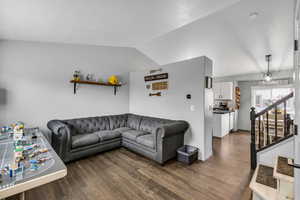 Living area with dark wood-style floors and vaulted ceiling