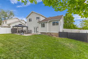 Rear view of property featuring a gazebo, a patio area, and beautiful lawn