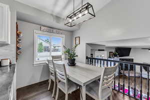 Dining room featuring wood finished floors, baseboards, and a chandelier