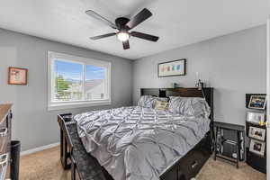 Carpeted bedroom featuring baseboards and a ceiling fan