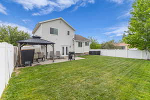 Rear view of property featuring a fully fenced yard, gazebo, and a patio area