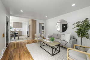 Living room with light wood-style floors and recessed lighting