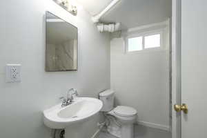 Bathroom with a sink, toilet, and baseboards