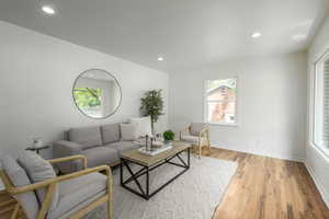 Living area with light wood finished floors, healthy amount of natural light, recessed lighting, and baseboards
