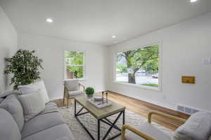 Living area with baseboards, recessed lighting, and light wood-style floors