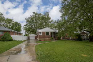 Bungalow featuring brick siding, an outbuilding, and a detached garage