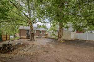 Rear view of house featuring fence and brick siding