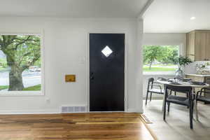 Foyer entrance featuring light wood-style flooring, healthy amount of natural light, and baseboards
