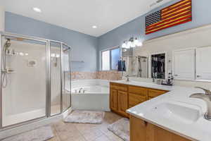 Full bathroom with a stall shower, a garden tub, tile patterned floors, and double vanity