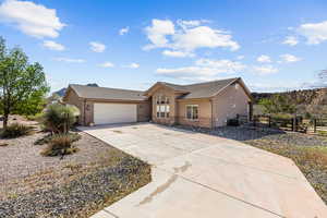 Ranch-style house featuring stucco siding, a tiled roof, fence, and an attached garage