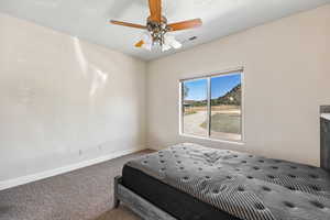Carpeted bedroom featuring baseboards and ceiling fan