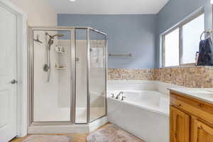 Full bathroom with a shower stall, a bath, tile patterned floors, and vanity