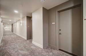 Hallway with baseboards and recessed lighting