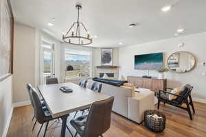 Dining space with recessed lighting, a chandelier, baseboards, wood finished floors, and a fireplace