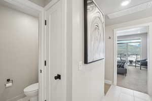 Bathroom featuring baseboards, toilet, and tile patterned flooring
