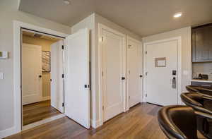 Corridor featuring wood finished floors, recessed lighting, and baseboards