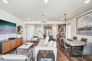 Living room with wood finished floors, recessed lighting, and a chandelier