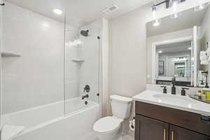 Full bath with toilet, vanity, and shower / washtub combination