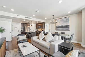 Living area with a chandelier, wood-type flooring, recessed lighting, and baseboards
