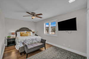 Bedroom with baseboards, wood finished floors, and a ceiling fan