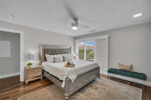 Bedroom featuring wood finished floors, baseboards, ceiling fan, and a textured ceiling