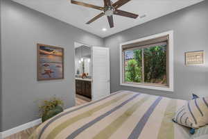 Bedroom with light wood finished floors, baseboards, connected bathroom, recessed lighting, and ceiling fan