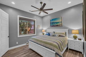 Bedroom featuring wood finished floors, recessed lighting, baseboards, and a ceiling fan