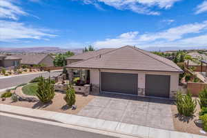 Single story home with stone siding, driveway, a mountain view, and stucco siding