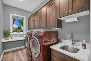 Laundry room featuring cabinet space, washing machine and clothes dryer, and baseboards