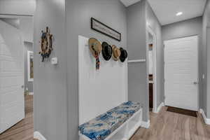 Mudroom with light wood-style flooring and baseboards