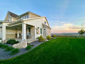 View of property exterior featuring a yard, a porch, and stone siding