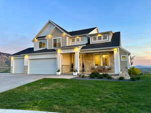 View of front of home featuring board and batten siding, covered porch, stone siding, and driveway