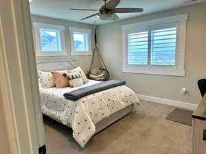 Carpeted bedroom with baseboards and a ceiling fan