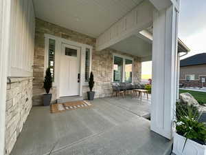 Doorway to property featuring covered porch and stone siding