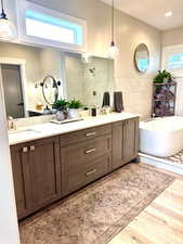 Bathroom with plenty of natural light, tile walls, a freestanding bath, tiled shower, and wood finished floors