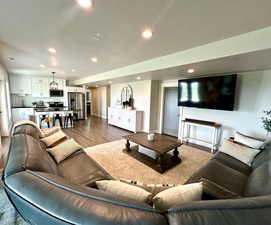 Living area featuring wood finished floors, recessed lighting, baseboards, and a textured ceiling