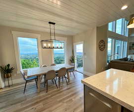 Dining room with plenty of natural light, light wood-type flooring, baseboards, wood ceiling, and recessed lighting