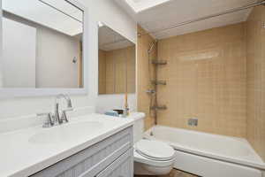 Bathroom with toilet, bathing tub / shower combination, and vanity
