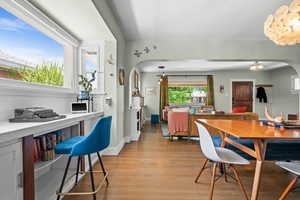 Dining area featuring arched walkways, light wood-type flooring, and baseboards