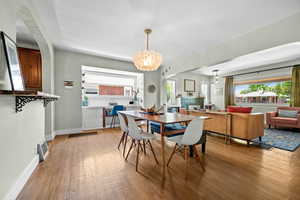 Dining area featuring light wood-style floors, a chandelier, and baseboards