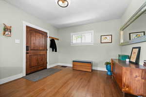 Foyer entrance with wood finished floors and baseboards