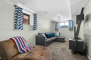 Carpeted living room with a textured ceiling and baseboards